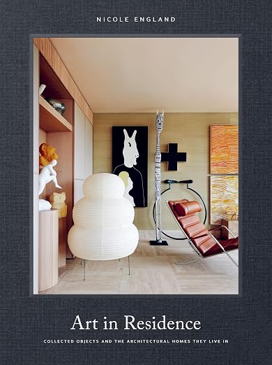 Art in Residence book cover by Nicole England, living room interior with a paper lantern lamp, sculptures, and a leather chair