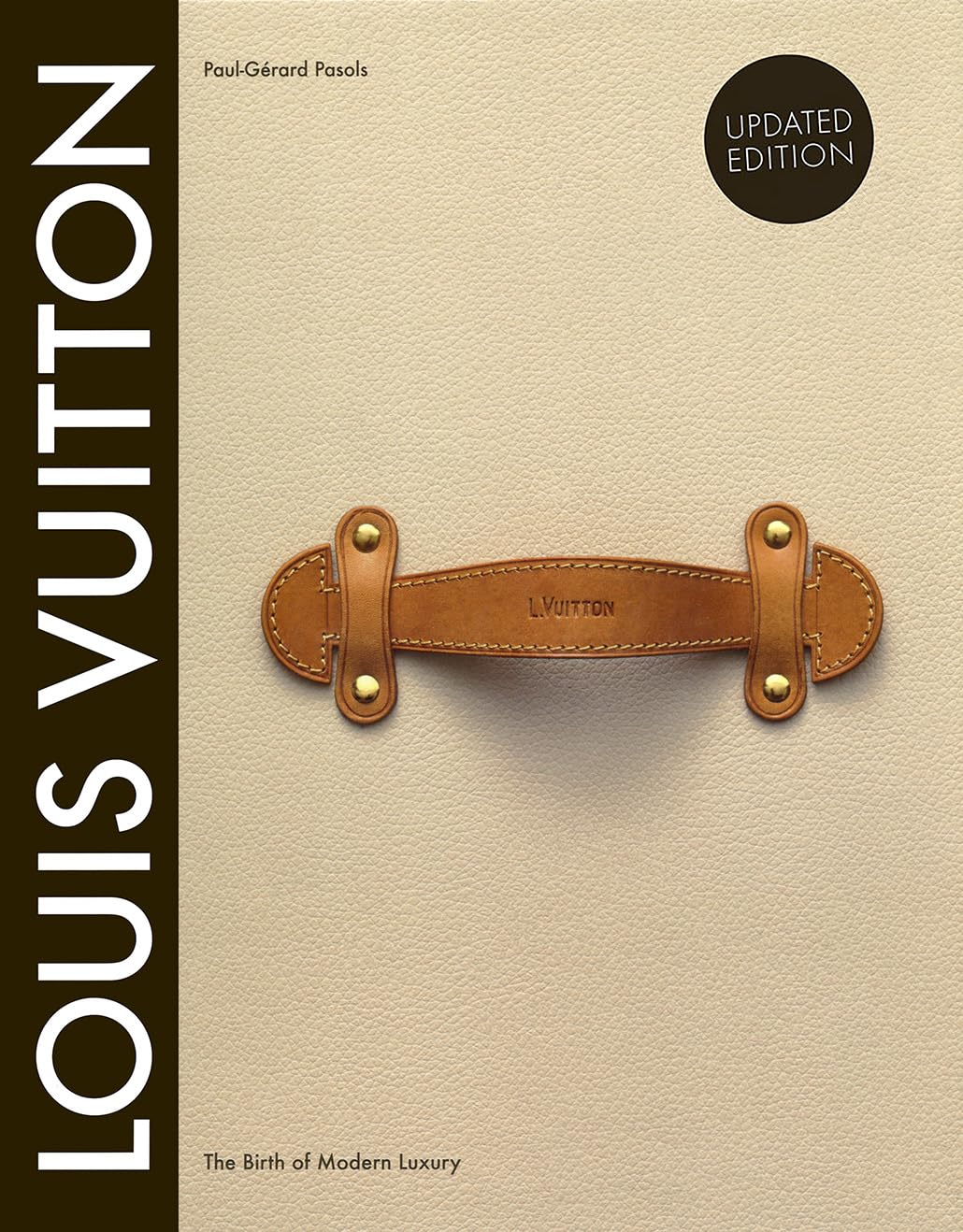 Louis Vuitton The Birth of Modern Luxury book cover, tan leather with brown leather trunk handle detail, updated edition seal